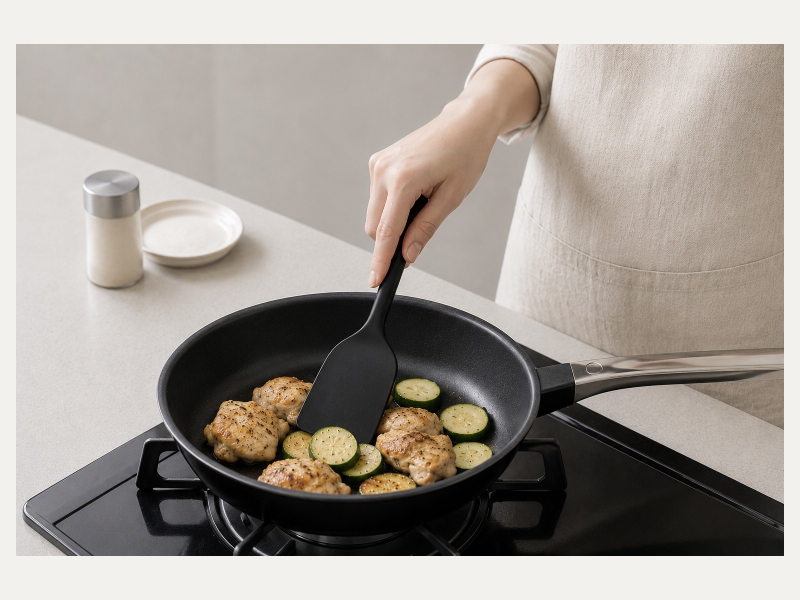 黒いシリコーンターナーでフライパンの食材を整えているHARON HOMEの調理シーン